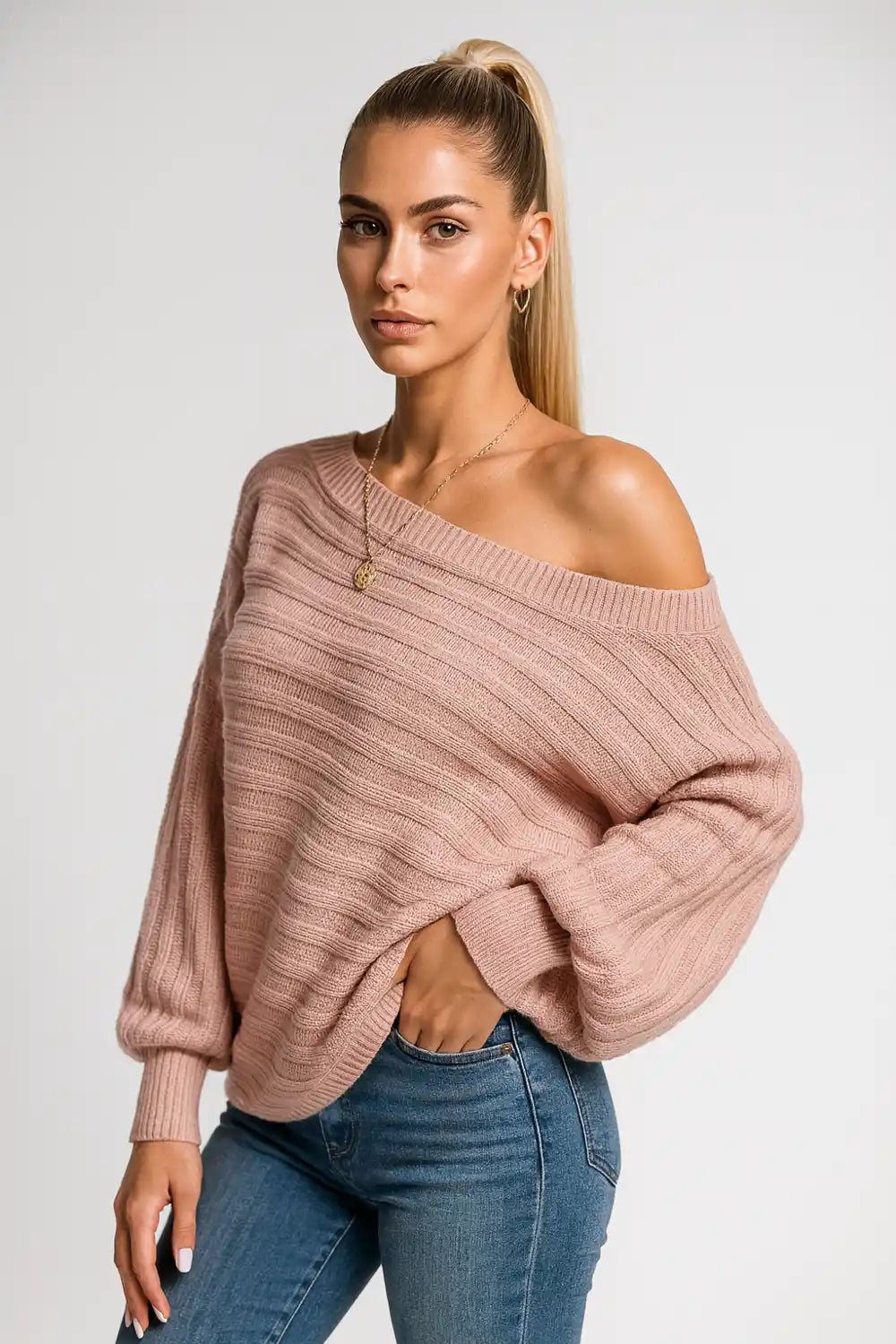 woman wearing a pink off-shoulder ribbed sweater styled with denim for a casual chic look